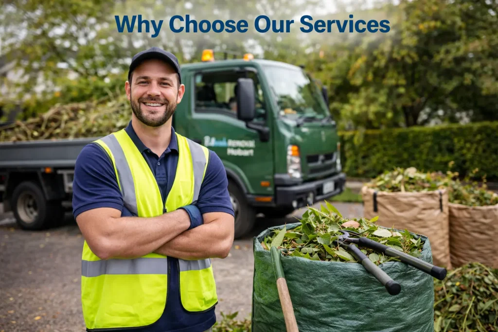 Worker of Rubbish Removal Hobart in a high-visibility vest stands with arms crossed near garden waste bags and a green service truck outdoors.